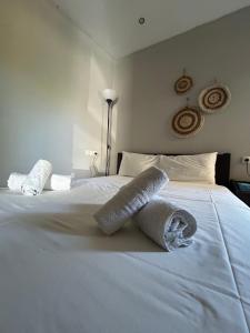 a white bed with two rolled towels on it at Casa de Kalika in Chania