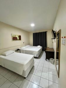 a hotel room with two beds and a television at Hotel Concord e Eventos corporativos Campo Grande in Campo Grande