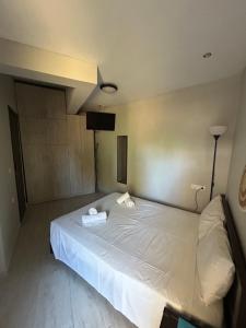 a bedroom with a large white bed with towels on it at Casa de Kalika in Chania