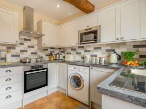 a kitchen with white cabinets and a washer and dryer at 1 Bed in Brecon BN015 in Brecon +18 photos