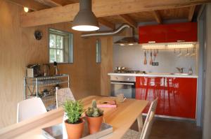 une cuisine avec une table en bois et des placards rouges dans l'établissement Klein Dubbelland, à Doorn