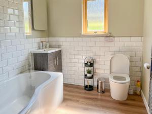 Un baño con bañera, inodoro y lavabo. en Cluny, en Aberfeldy