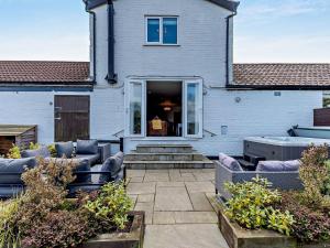 un patio avec des canapés et des chaises devant une maison dans l'établissement 3 Bed in Melton Mowbray 61788, à Melton Mowbray