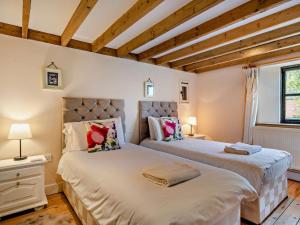 two beds in a room with wooden ceilings at 3 Bed in Shaftesbury 95685 in Sedghill