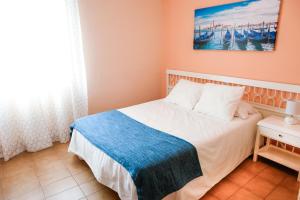 a bedroom with a bed and a painting on the wall at Hostal Isla Playa in Isla