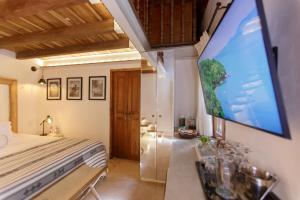 a bedroom with a bed and a flat screen tv at Palmas de Alba Hotel Boutique in Cartagena de Indias
