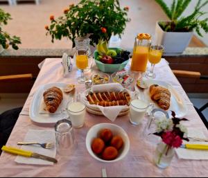a table with breakfast foods and glasses of orange juice at San Marino Hotel in Vlorë