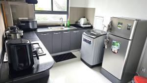 a small kitchen with a refrigerator and a stove at Biyanka's lovely apartment in Sri Jayewardenepura Kotte
