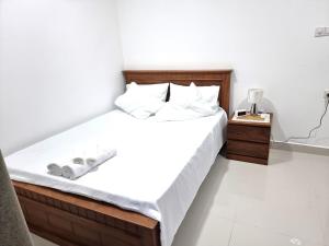 ein Bett mit weißen Laken und Kissen in einem Zimmer in der Unterkunft Biyanka's lovely apartment in Sri Jayewardenepura Kotte + 10 Fotos