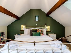 a bedroom with a large bed with a green wall at 1 Bed in Llangollen 78471 in Glyn-Ceiriog