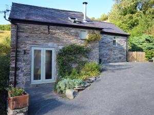 a small stone house with a driveway at 1 Bed in Llangollen 78471 in Glyn-Ceiriog