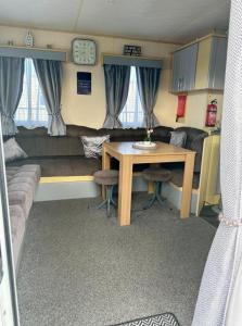 a living room with a table and a couch at Avas Special Place in Ingoldmells