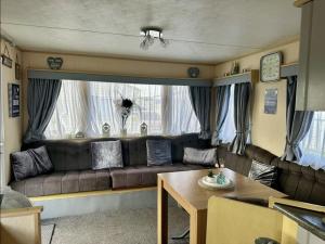 a living room with a couch and a table at Avas Special Place in Ingoldmells