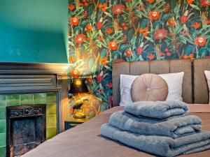 1 cama con toallas y pared de flores en 5 Bed in Monmouth 94050, en Monmouth