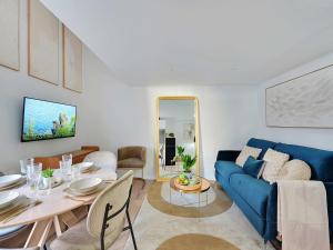 a living room with a blue couch and a table at Charming Apartment -1BR 4P- Le Kremlin-Bicêtre in Le Kremlin-Bicêtre