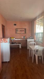 a kitchen with a white refrigerator and a table at Cabañas Alba in Caleta de Campos