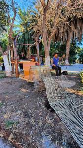 a man sitting on a bench in a park at Casa Alojamiento TELAR DE SUEÑOS in Belén