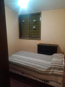 a bedroom with a bed with a window and a dresser at Casa Alojamiento TELAR DE SUEÑOS in Belén