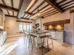 kuchnia z dużą wyspą w centrum miasta z barowymi stołkami w obiekcie 4 Bed in Denbigh 62947 w mieście Llannefydd +37 zdjęć