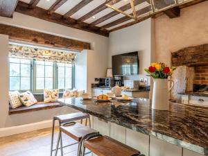 kuchnia z blatem z krzesłami i stołem w obiekcie 4 Bed in Denbigh 62947 w mieście Llannefydd