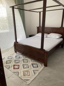a bedroom with a bed with a wooden frame at Coral Whispers in Malindi +32 photos