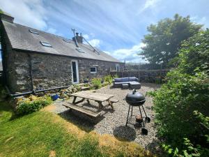 a stone house with a picnic table and a grill at 3 Bed in Eskdale 94529 in Eskdale