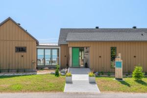 a home with a green door and a building at La Bergerie in Saint-Joseph-de-la-Rive