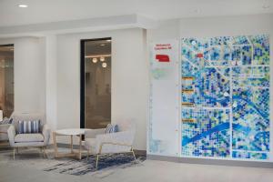 a lobby with chairs and a large painting on the wall at TownePlace Suites by Marriott Columbus in Columbus