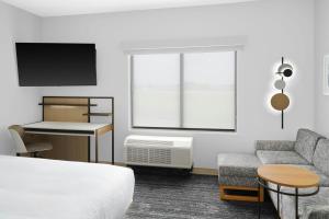 a hotel room with a bed and a couch and a desk at TownePlace Suites by Marriott Columbus in Columbus +33 photos