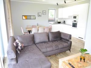 a living room with a brown couch and a table at New, large holiday home for 10 people in Kołczewo