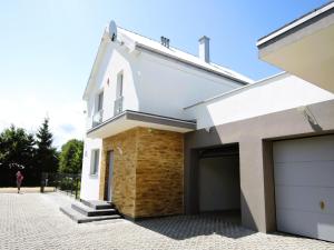 a white house with two garage doors at New, large holiday home for 10 people in Kołczewo
