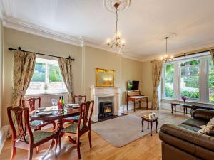 Una sala de estar con una mesa y una chimenea. en 1 Bed in PENMAENMAWR 95495, en Penmaen-mawr