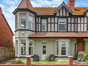 a large black and white house with benches in front at 4 Bed in Llandudno 95235 in Llandudno