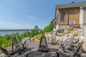 a group of chairs sitting on a patio next to a house at La Bergerie in Saint-Joseph-de-la-Rive
