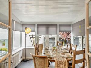 a dining room with a table and chairs and windows at 4 Bed in Llandudno 95235 in Llandudno