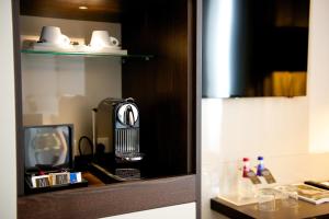 a kitchen with a microwave and a coffee maker at Hotel Cerretani Firenze - MGallery Collection in Florence
