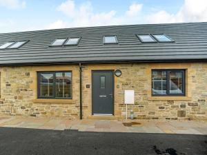 una casa de ladrillo con una puerta y ventanas negras en 3 Bed in Seahouses 81486, en Seahouses