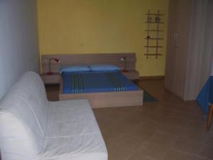 マルサラにあるDi Fronte la spiaggiaのベッドルーム(ベッド1台、ソファ付)