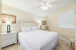 a bedroom with a white bed and a ceiling fan at Perdido Sun Unit 914 in Pensacola