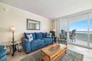 a living room with a blue couch and a view of the ocean at Perdido Sun Unit 914 in Pensacola