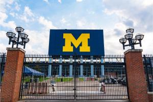 a large sign for acedes benz stadium with the m on it at 2 Luxe 2BR Apts Near Big House w Parking & Gym in Ann Arbor