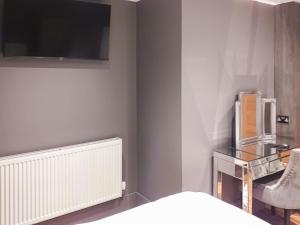 a bedroom with a bed and a tv on the wall at The Inn And Around in Kenton +5 photos