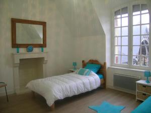 a bedroom with a bed with a fireplace and a mirror at Spacieux gîte près d'un château avec parc, 4 chambres, 2 sdb, Wifi, et animaux acceptés. - FR-1-489-215 in Trévol