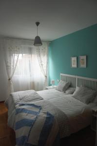a bedroom with a large bed with a blue wall at Apartamento Ermitagaña in Pamplona