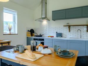 a kitchen with a wooden table with food on it at 1 Bed in Talybont-on-Usk 88137 in Talybont +17 photos