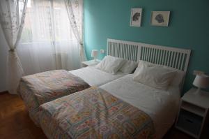 a bed with white sheets and pillows in a bedroom at Apartamento Ermitagaña in Pamplona