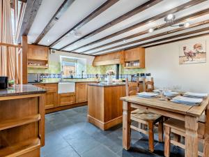 a large kitchen with wooden cabinets and a wooden table at 2 Bed in Launceston 95236 in Saint Giles on the Heath