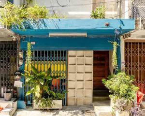 a store front with a blue awning and plants at Bali Style Rooftop Apartment in Bangkok
