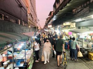 a crowd of people walking through an outdoor market at Bali Style Rooftop Apartment in Bangkok