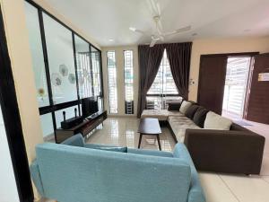 Una sala de estar con un sofá y un televisor. en Seri Austin 16pax 4bedroom 4bathroom, en Johor Bahru